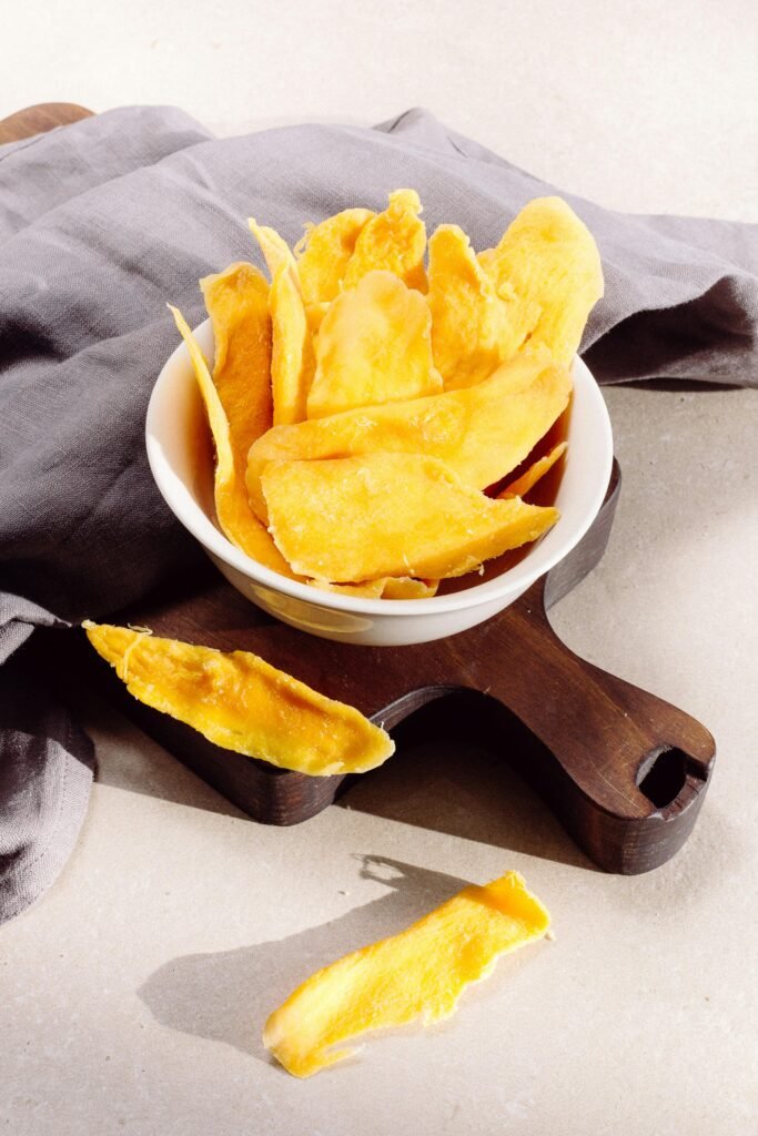 Bright and tasty homemade mango chips in a bowl, perfect for a healthy snack.